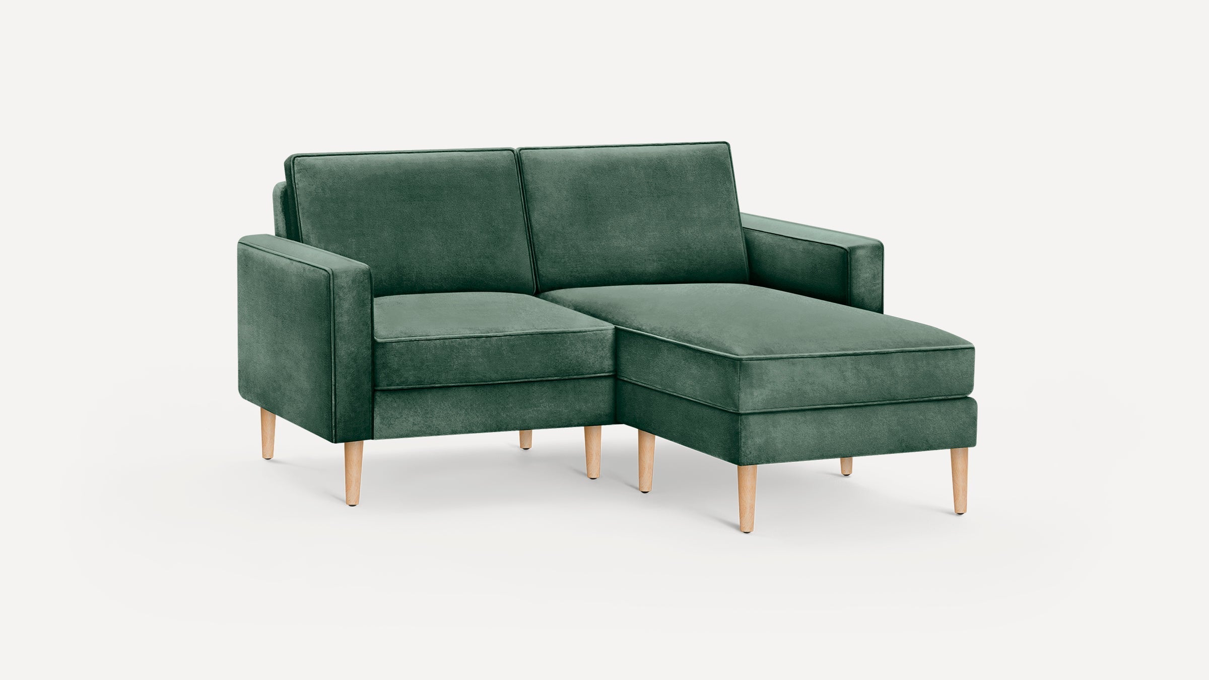 Green velvet modern sectional sofa with wooden legs, featuring a chaise lounge on the right side.