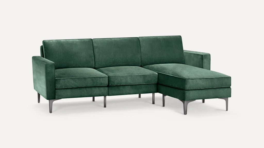 Modern green velvet L-shaped sectional sofa with clean lines, metal legs, and plush cushions against a white background.