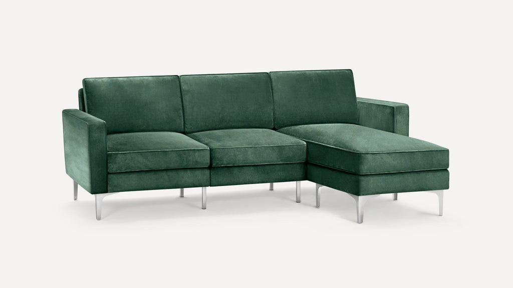 Green velvet sectional sofa with metal legs, featuring a chaise lounge on the right side, modern and sleek design.