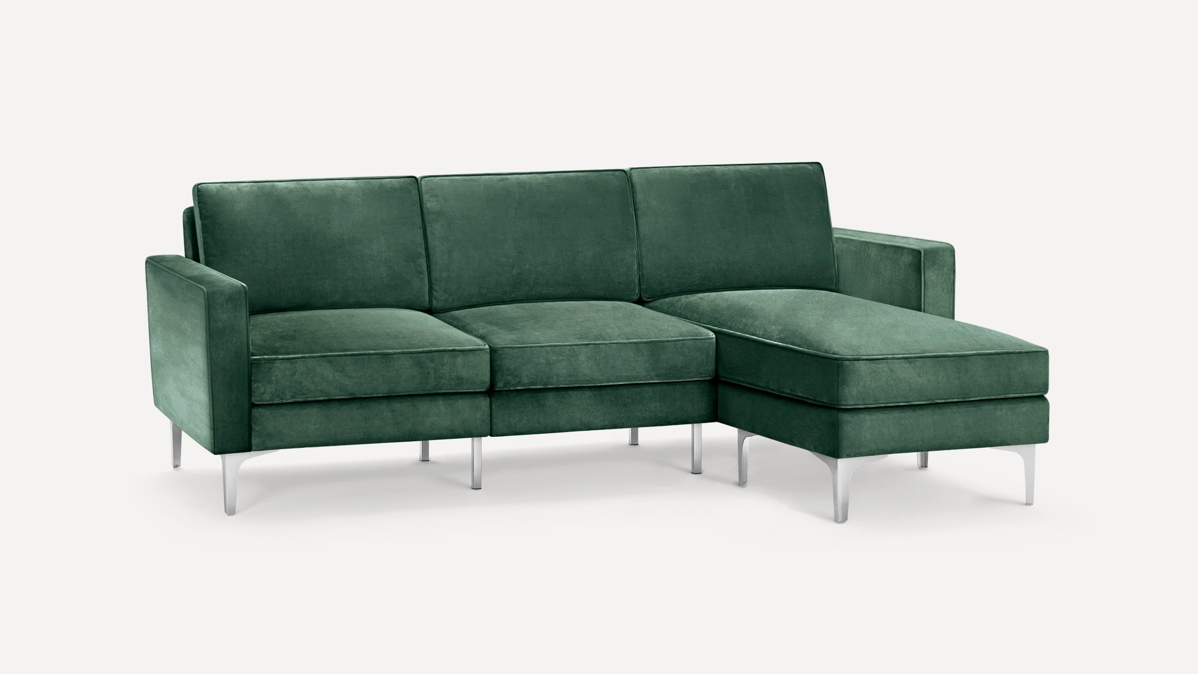 Green velvet sectional sofa with metal legs, featuring a chaise lounge on the right side, modern and sleek design.