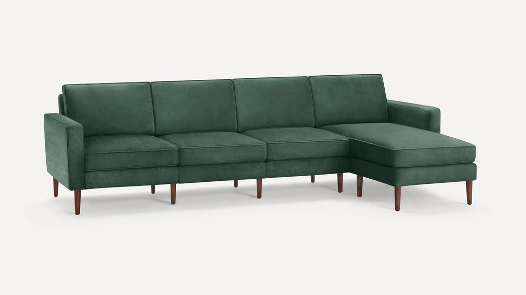 Dark green velvet sectional sofa with wooden tapered legs and right-side chaise lounge, modern mid-century design.