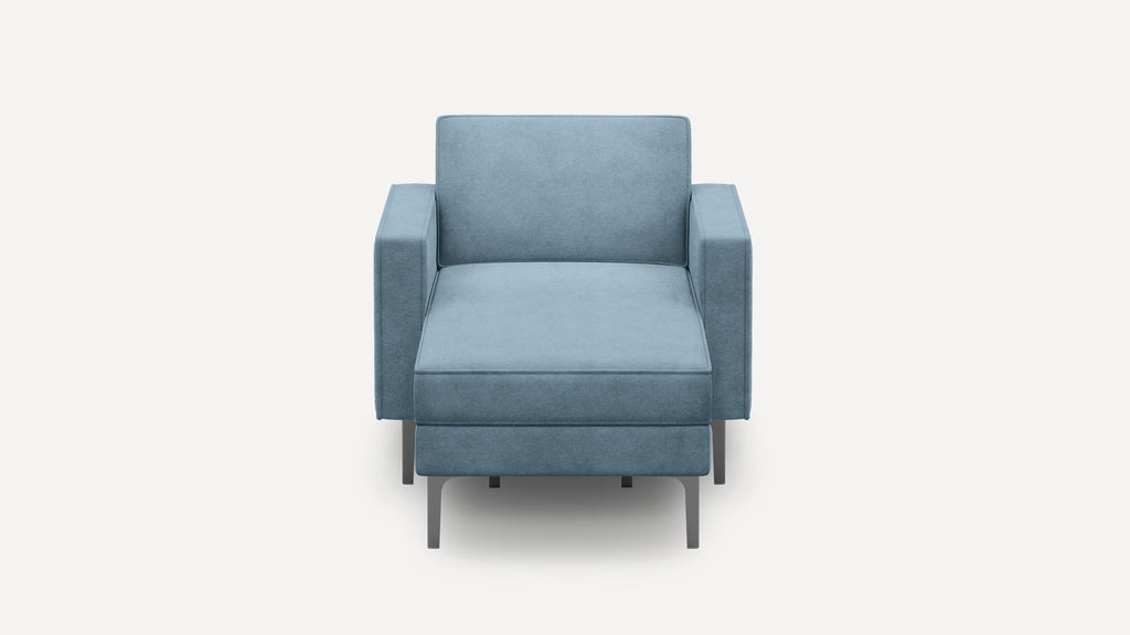 Front view of a modern, light blue upholstered armchair with square armrests and metal legs.