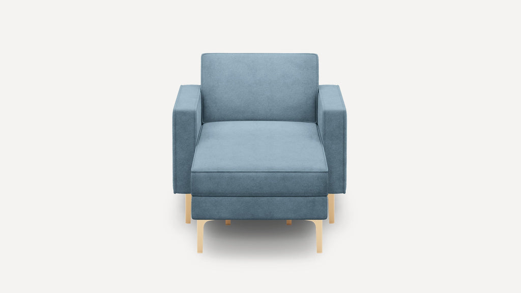 Front view of a modern, blue upholstered armchair with straight arms and light wooden legs against a plain white background.