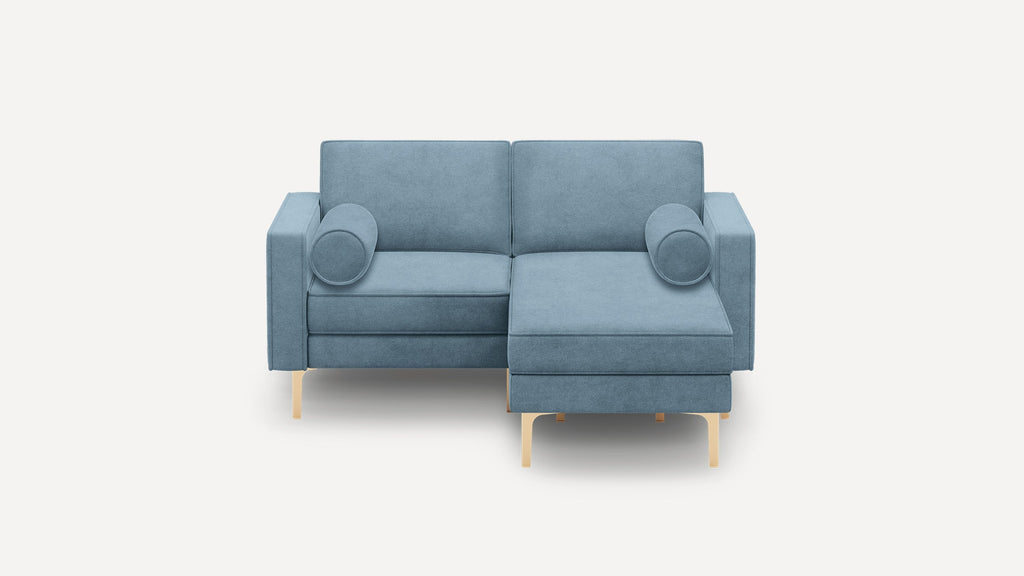 Modern blue fabric sectional sofa with gold legs and two round bolster pillows on a plain white background.