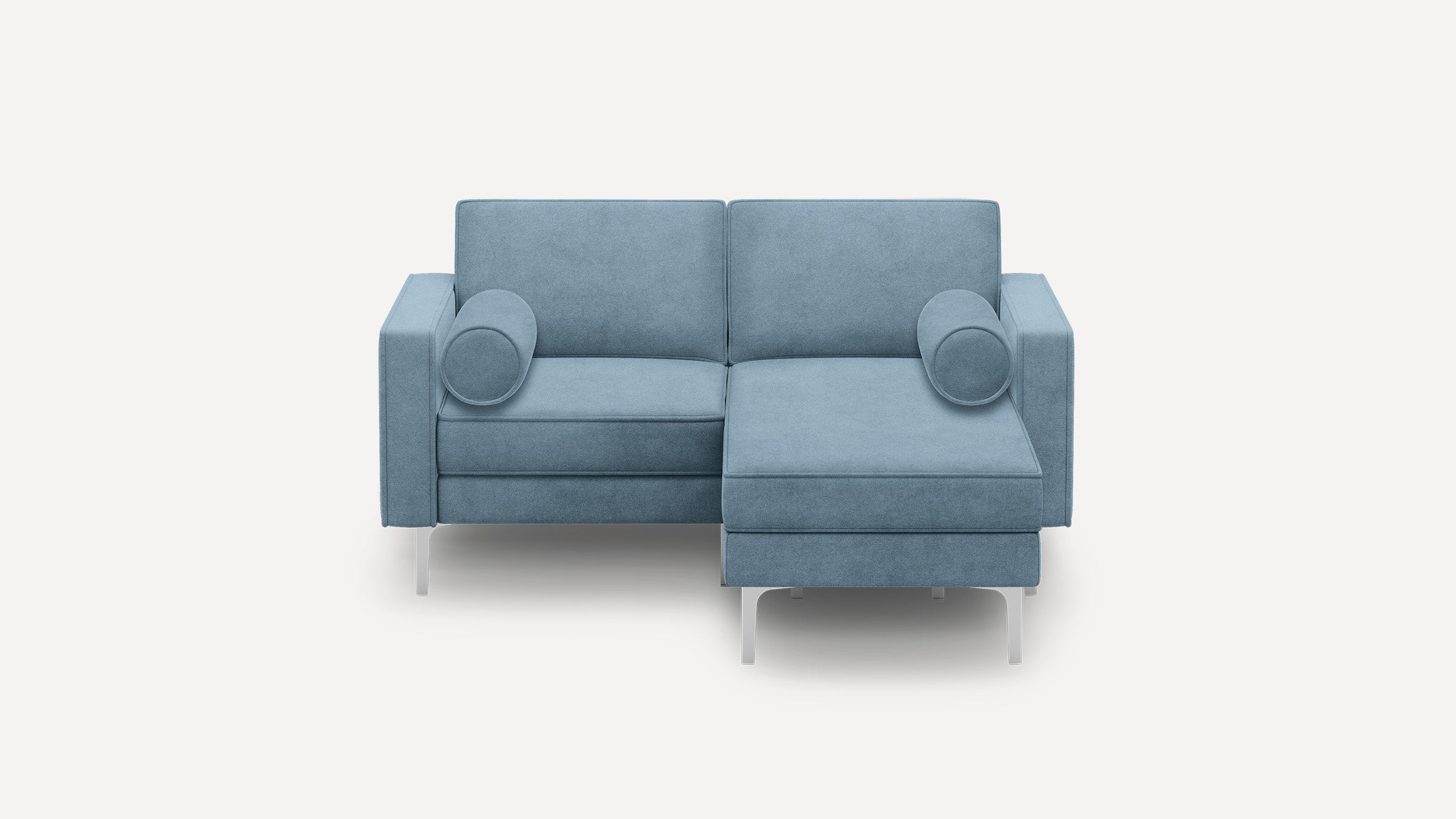 Modern two-seater sectional sofa with chaise lounge in light blue fabric, featuring cylindrical bolster pillows and slim metal legs.