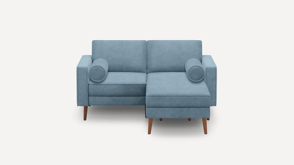 Light blue modern sectional sofa with wooden legs, square arms, and two round bolster pillows on a white background.