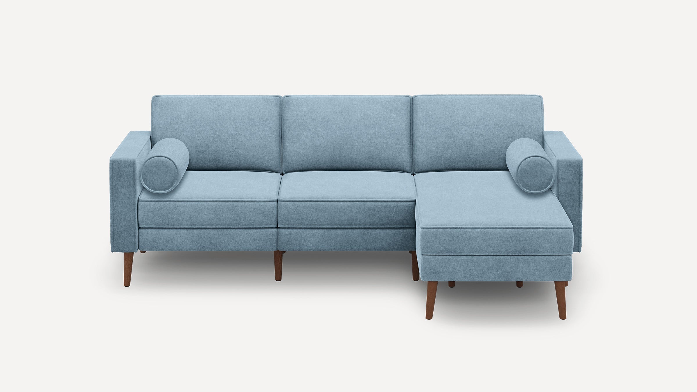light blue sectional sofa with chaise lounge and matching ottoman, featuring wooden legs, and a rounded cushioned backrest