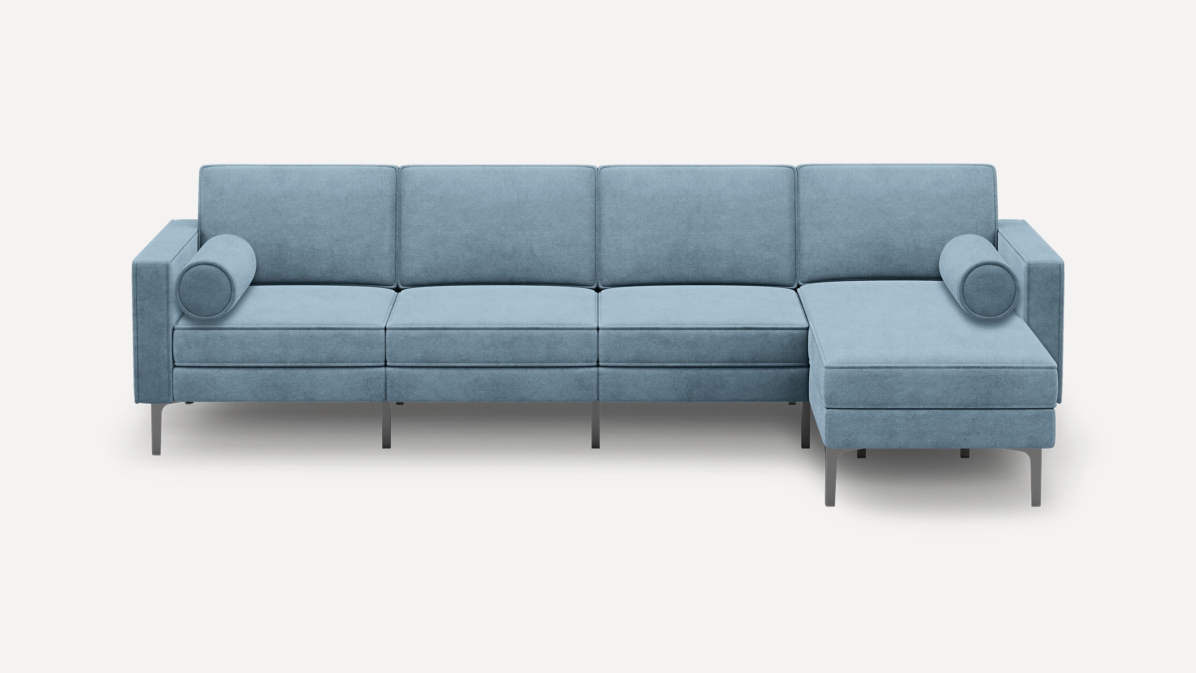 Light blue modern sectional sofa with metal legs, clean lines, and two cylindrical bolster pillows on each end.