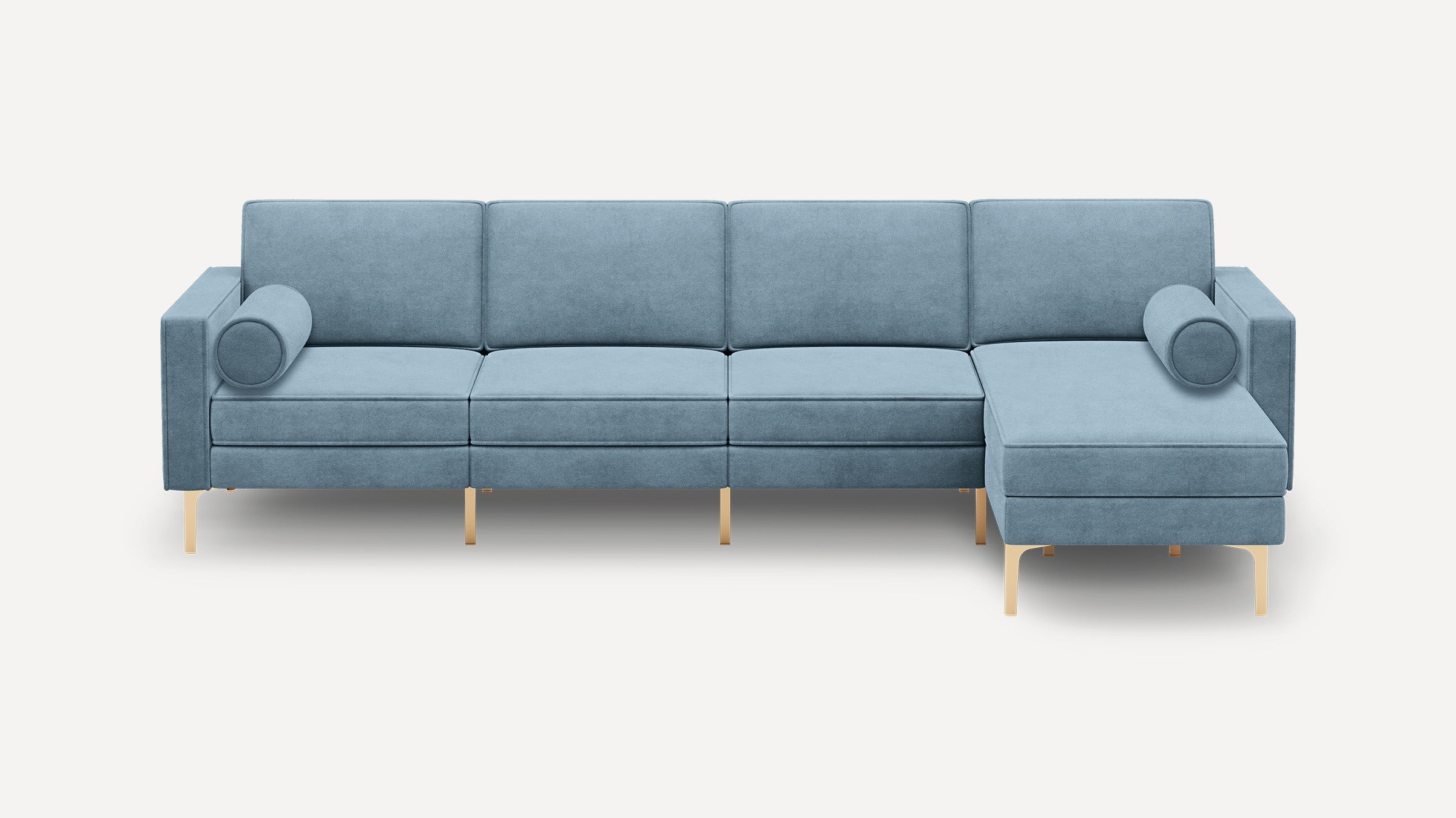 Modern light blue sectional sofa with gold metal legs, straight arms, and two cylindrical bolster pillows.