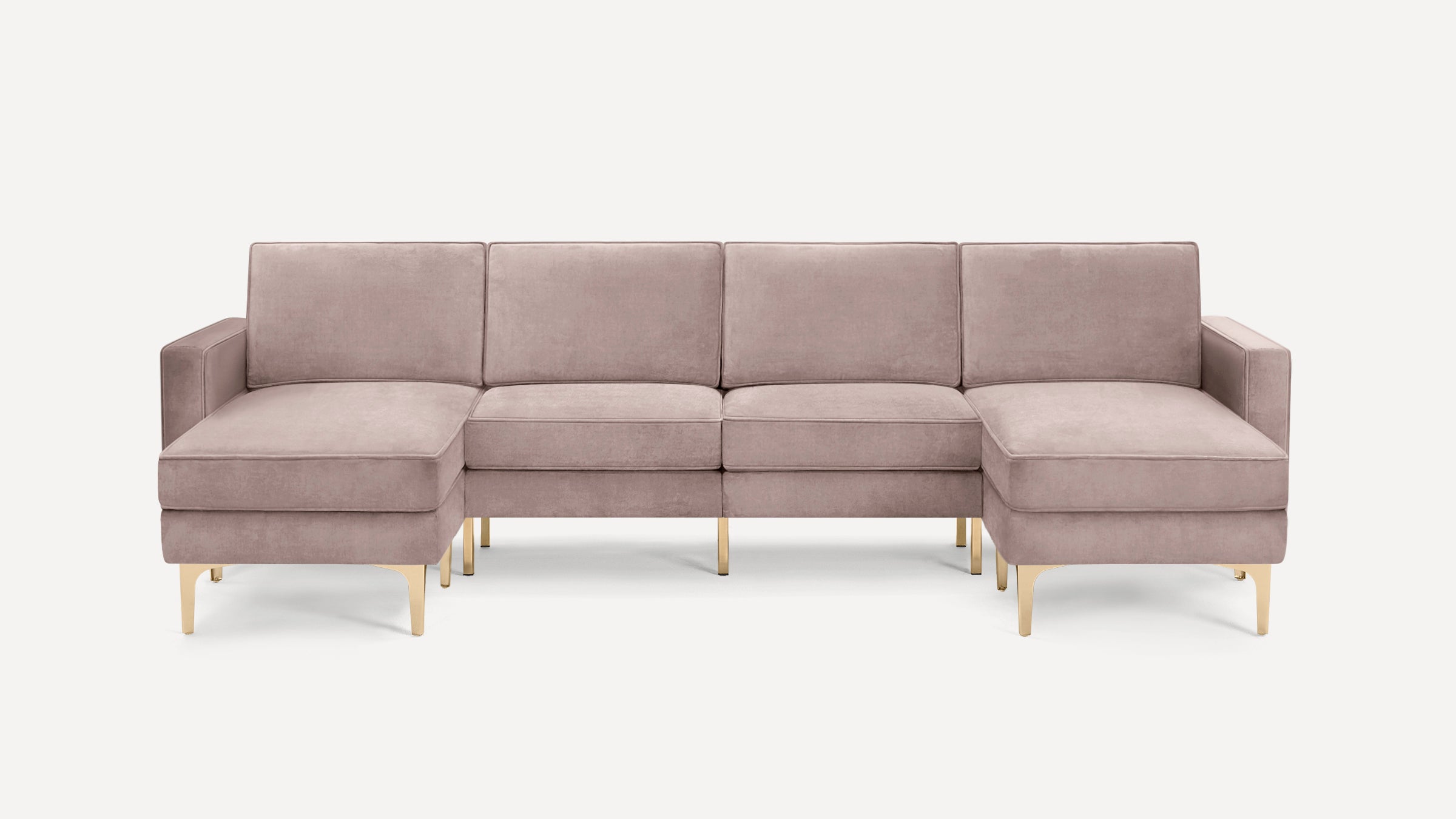 Modern U-shaped sectional sofa in muted pink velvet with gold metal legs, featuring clean lines and plush cushions.