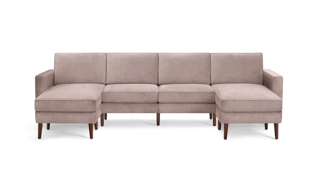 modern light pink velvet sectional sofa with wooden legs and clean lines on the back, featuring a chaise lounge and matching ottoman