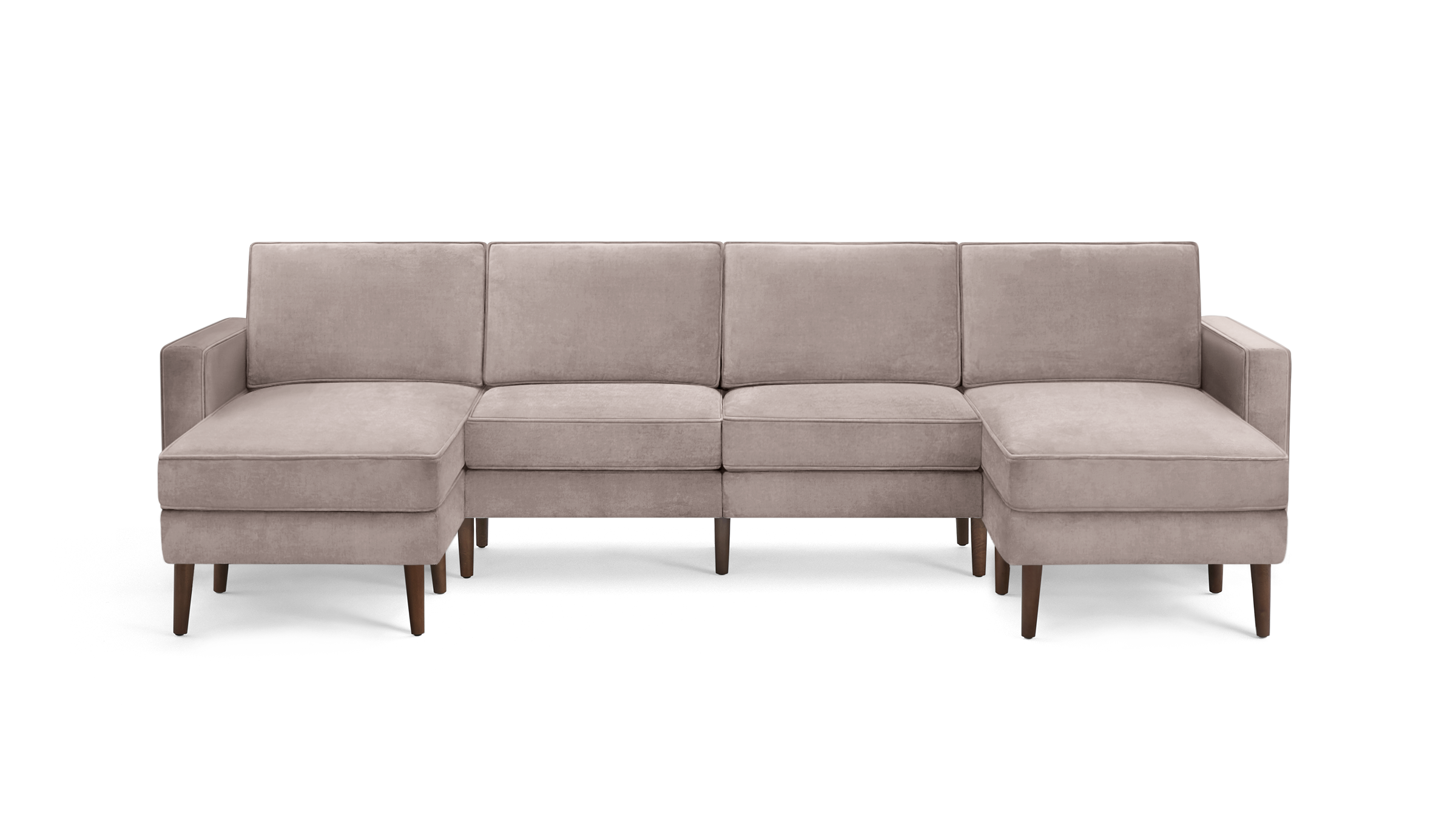 modern light pink velvet sectional sofa with wooden legs and clean lines on the back, featuring a chaise lounge and matching ottoman