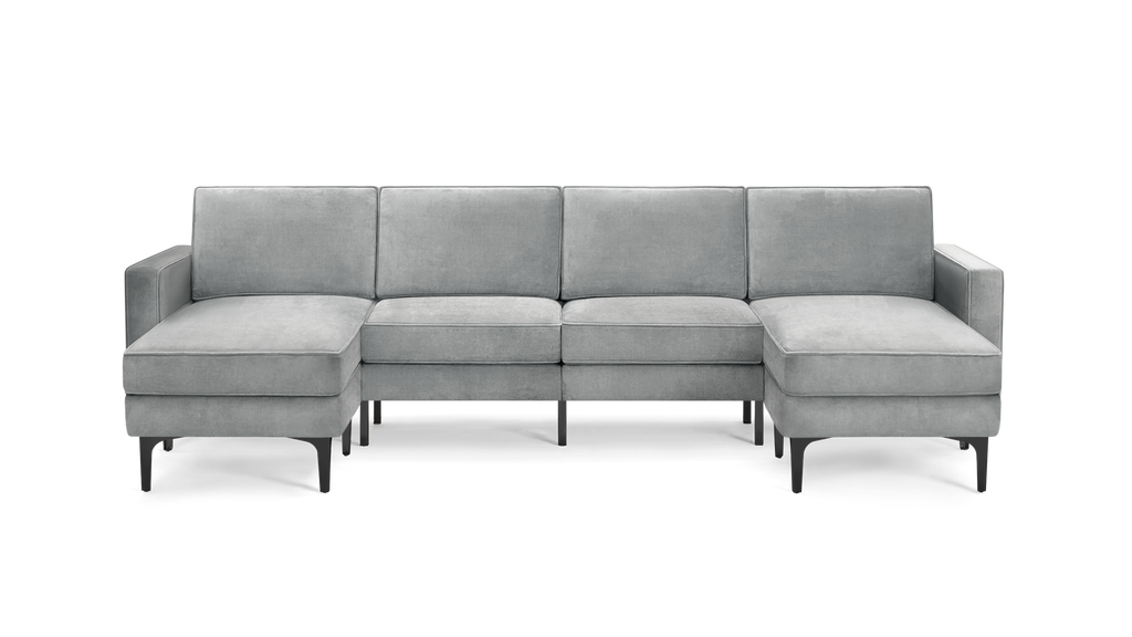 modern light gray velvet sectional sofa with chaise lounge and matching ottoman, featuring sleek black metal legs, on a white background