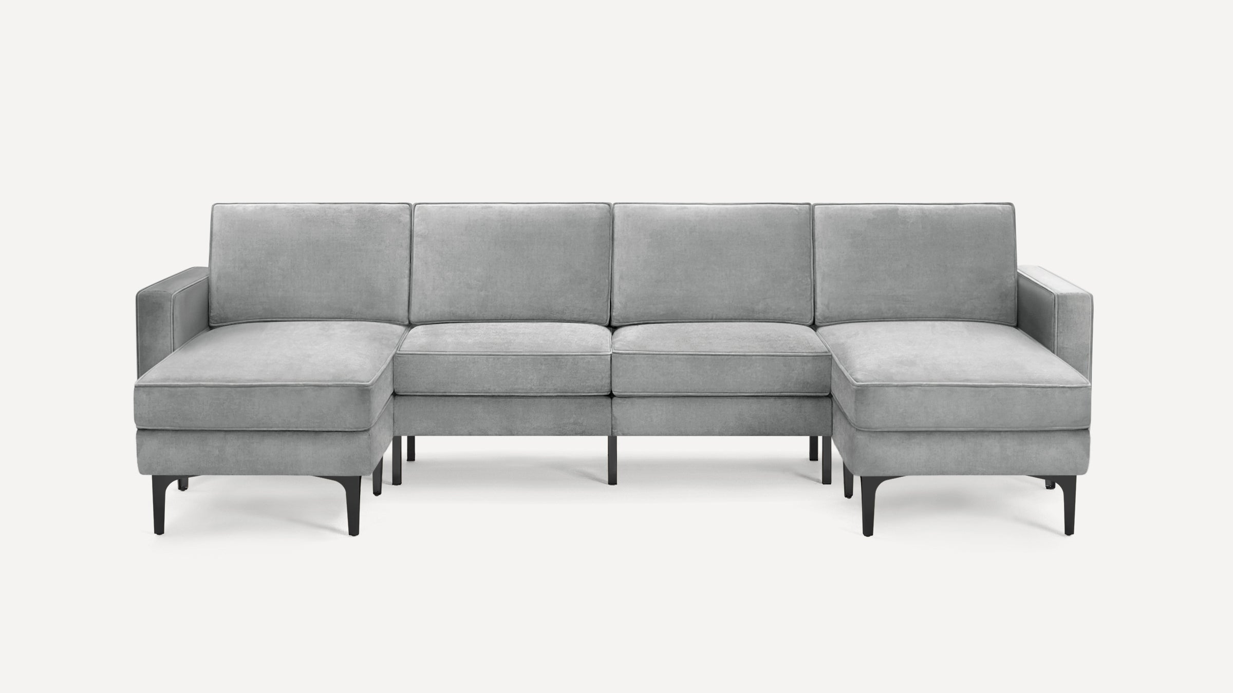 Light gray modern sectional sofa with velvet upholstery, high back cushions, armrests on both ends, and black slender legs.