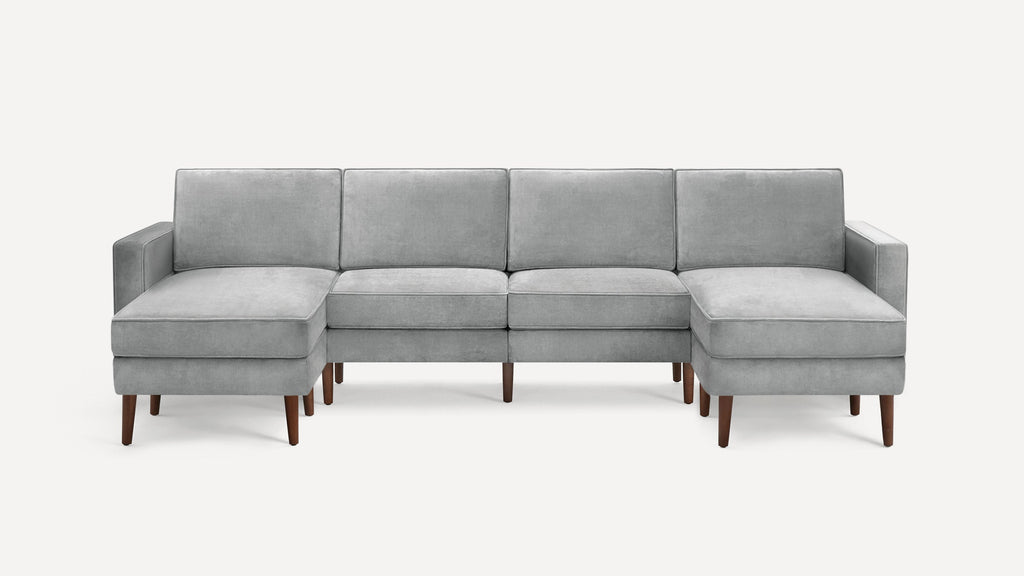 Modern light gray velvet sectional sofa with wooden legs, featuring two chaise lounges on each end and three seat cushions.