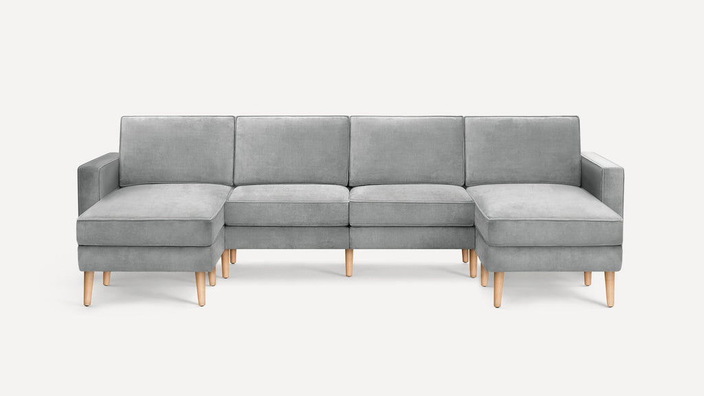 Modern gray sectional sofa with wooden legs, featuring two chaise lounges on either end and clean, simple lines.