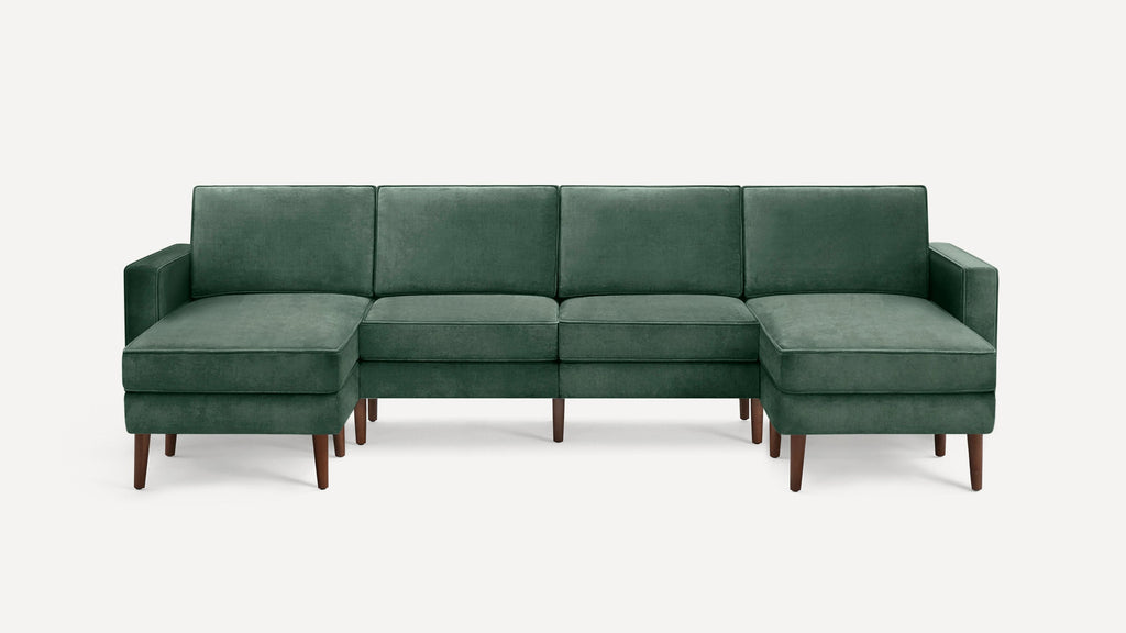 Green velvet sectional sofa with wooden legs, featuring a symmetrical design and cushioned armrests on both ends.