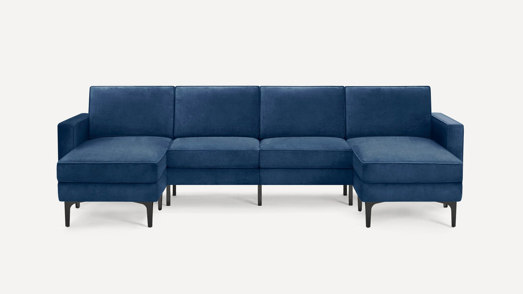 Modern sectional sofa in rich navy blue velvet fabric with sleek black legs, featuring chaise on both ends.