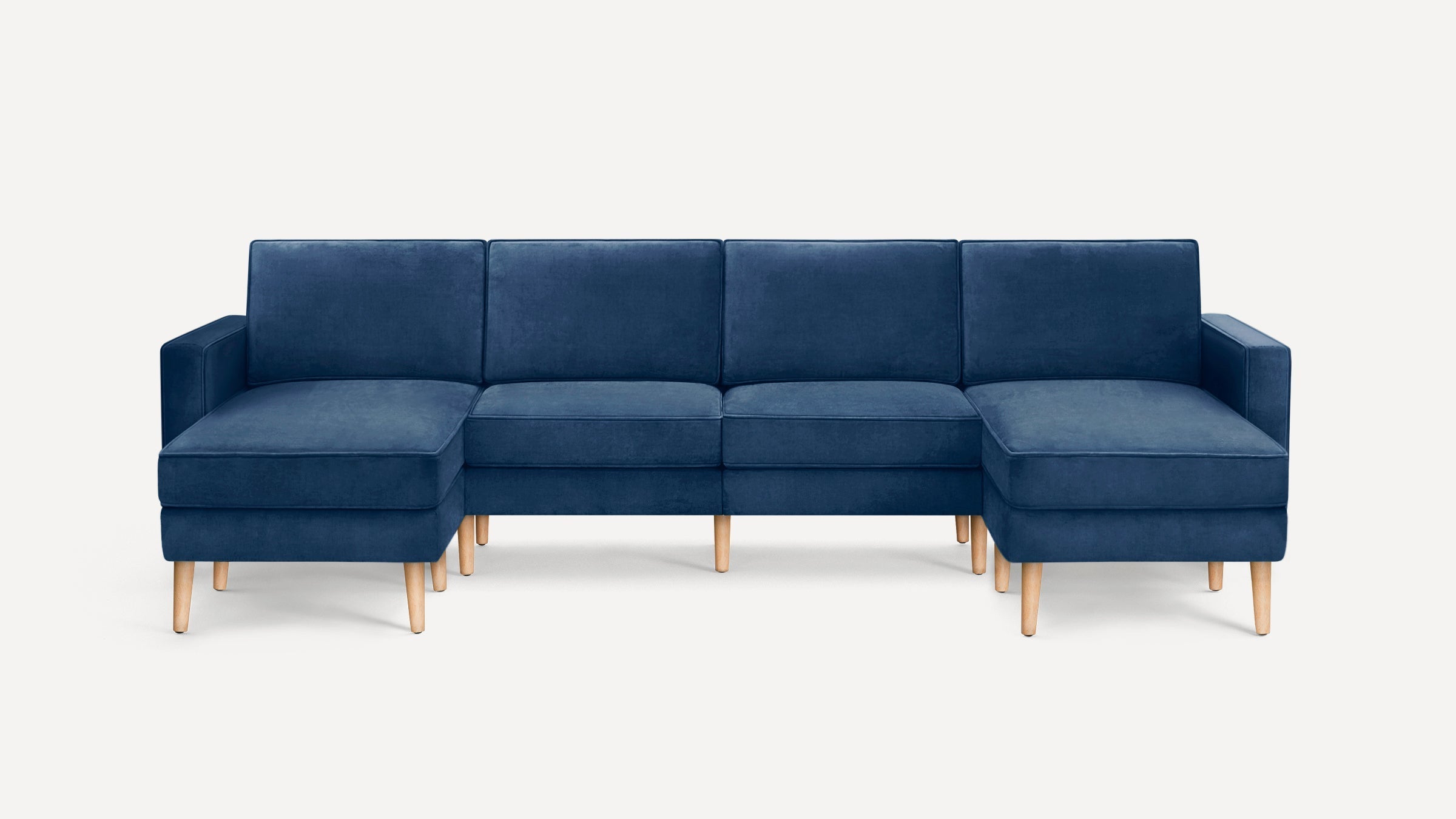 Modern navy blue sectional sofa with plush cushions, wooden legs, and a symmetrical L-shaped design on both ends.