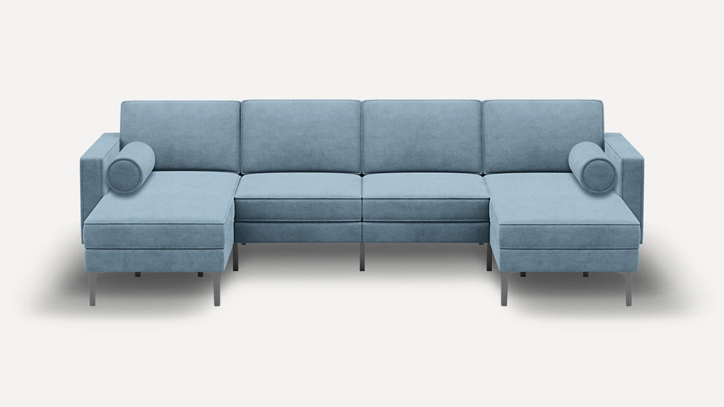Modern light blue sectional sofa with clean lines, metal legs, two chaise lounges, and cylindrical bolster pillows on each side.
