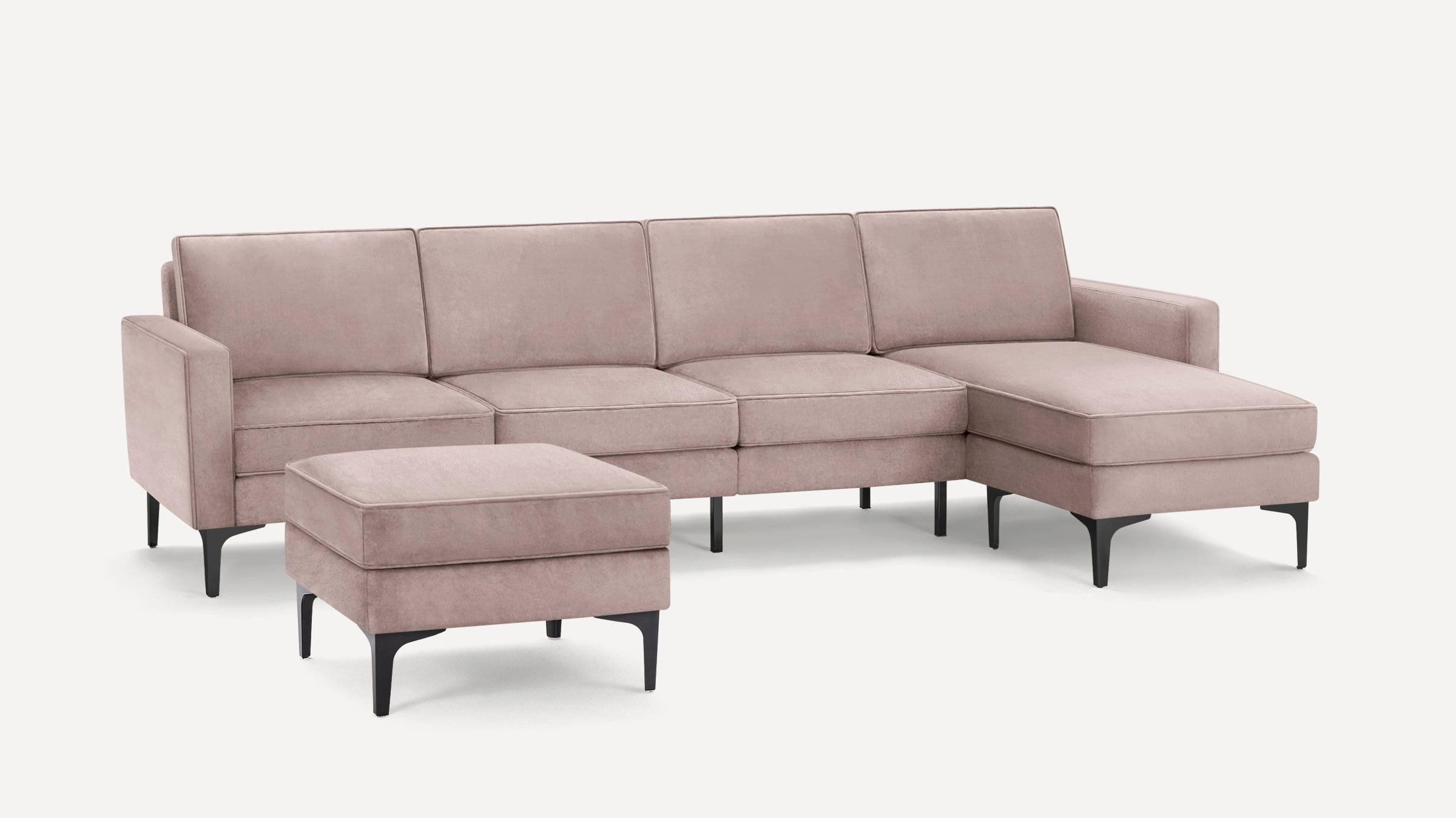 Light pink modern sectional sofa with black tapered legs and a matching ottoman on a white background.