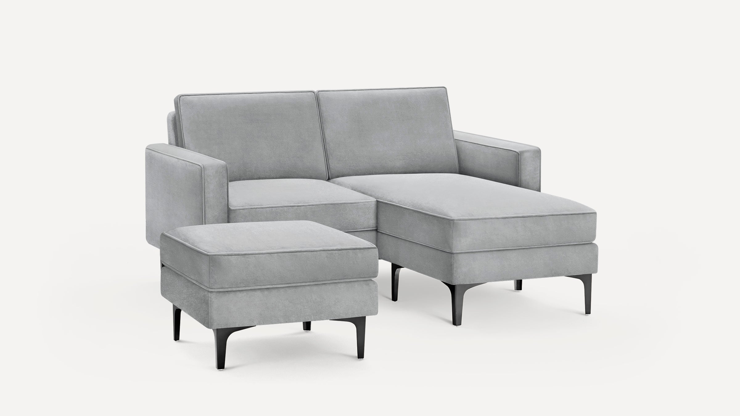 Modern light grey sectional sofa with chaise lounge and matching ottoman, featuring black tapered legs and clean, minimalist design.