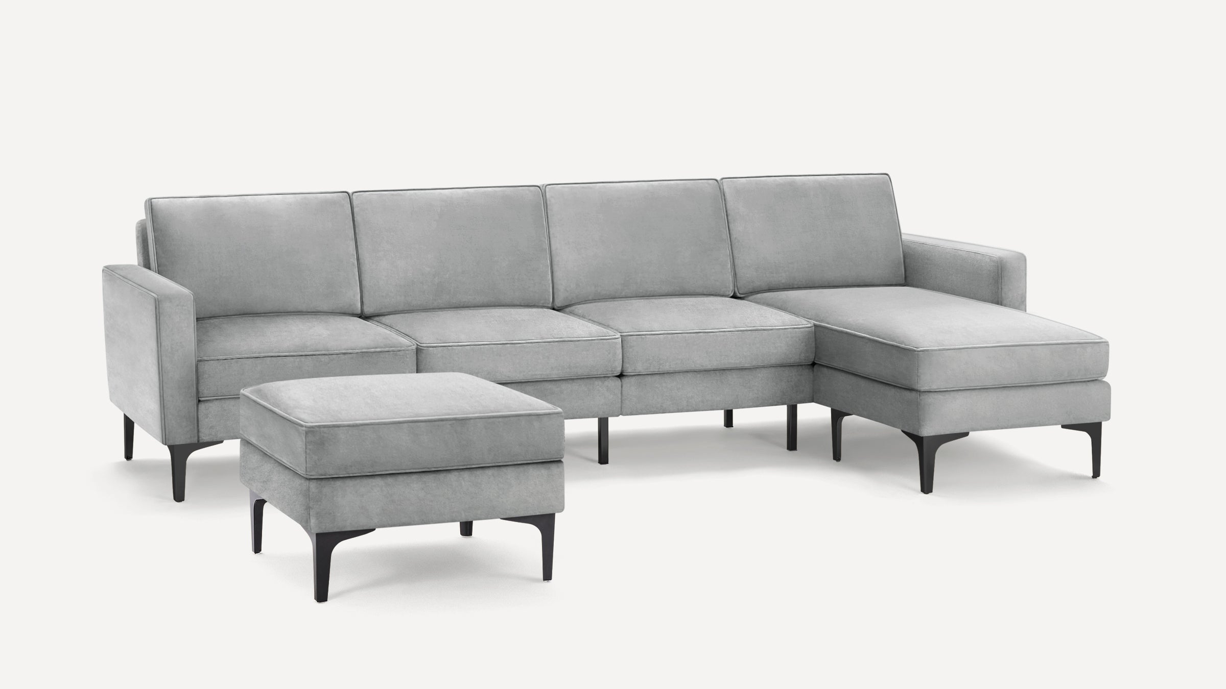 Light gray sectional sofa with chaise and matching ottoman, featuring sleek black legs and modern clean lines.