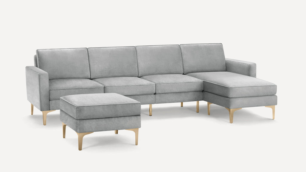 Light gray velvet sectional sofa with matching ottoman, both featuring sleek gold metal legs, modern and elegant design.