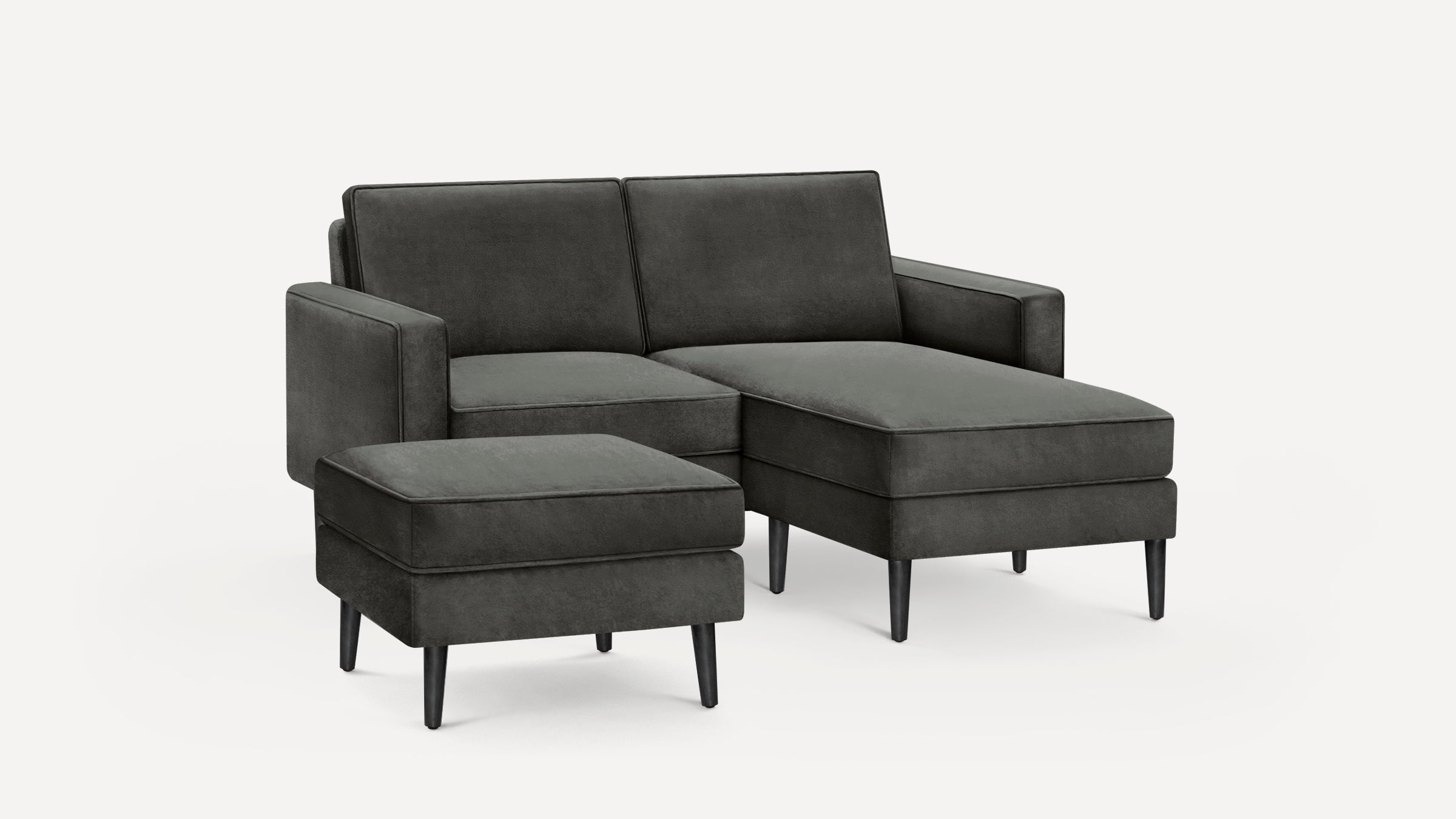 Dark gray modern sectional sofa with chaise lounge and matching ottoman, featuring clean lines and black tapered legs.