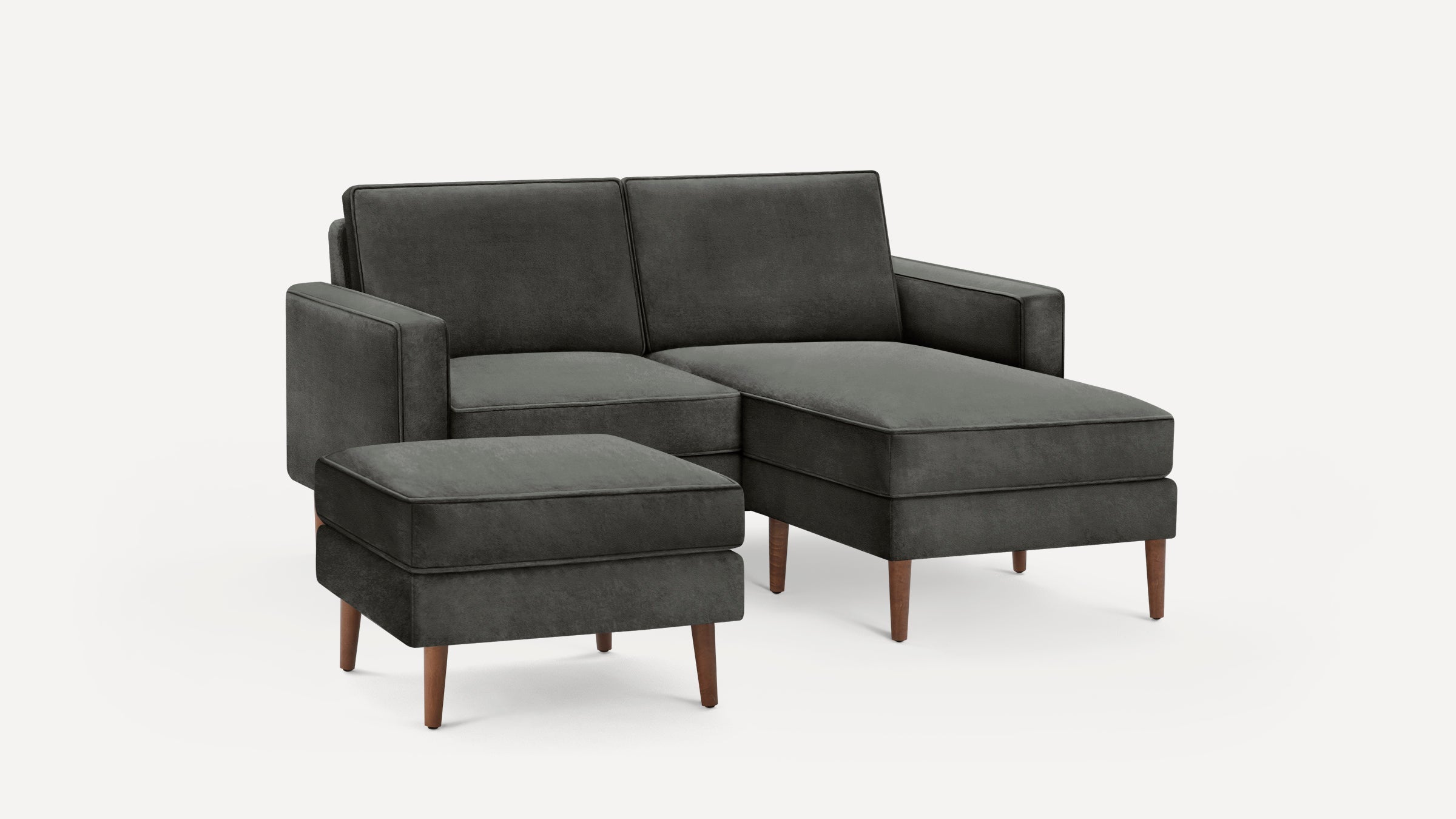 Dark gray upholstered sectional sofa with a matching ottoman, featuring clean lines and wooden legs.
