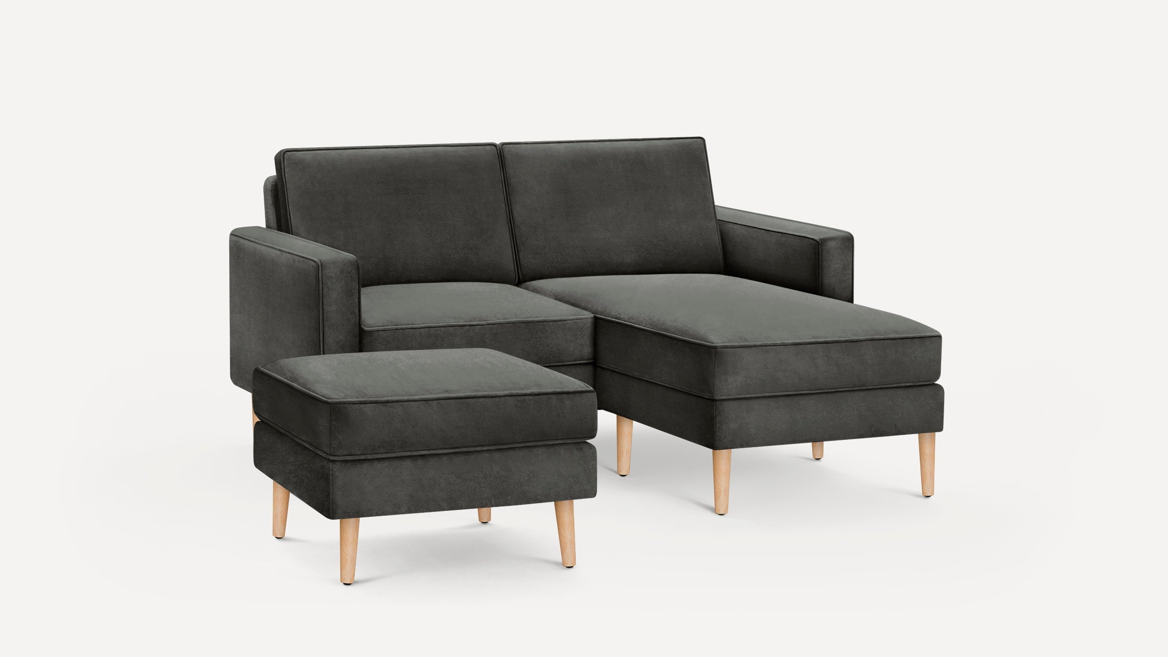 Dark gray modern sectional sofa with matching ottoman, wooden legs, and clean, minimalist design on white background.