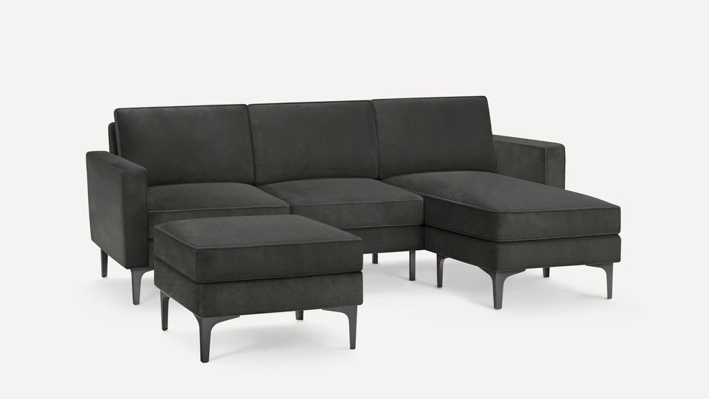 Dark gray sectional sofa with clean lines, metal legs, and a matching ottoman, designed for modern living spaces.