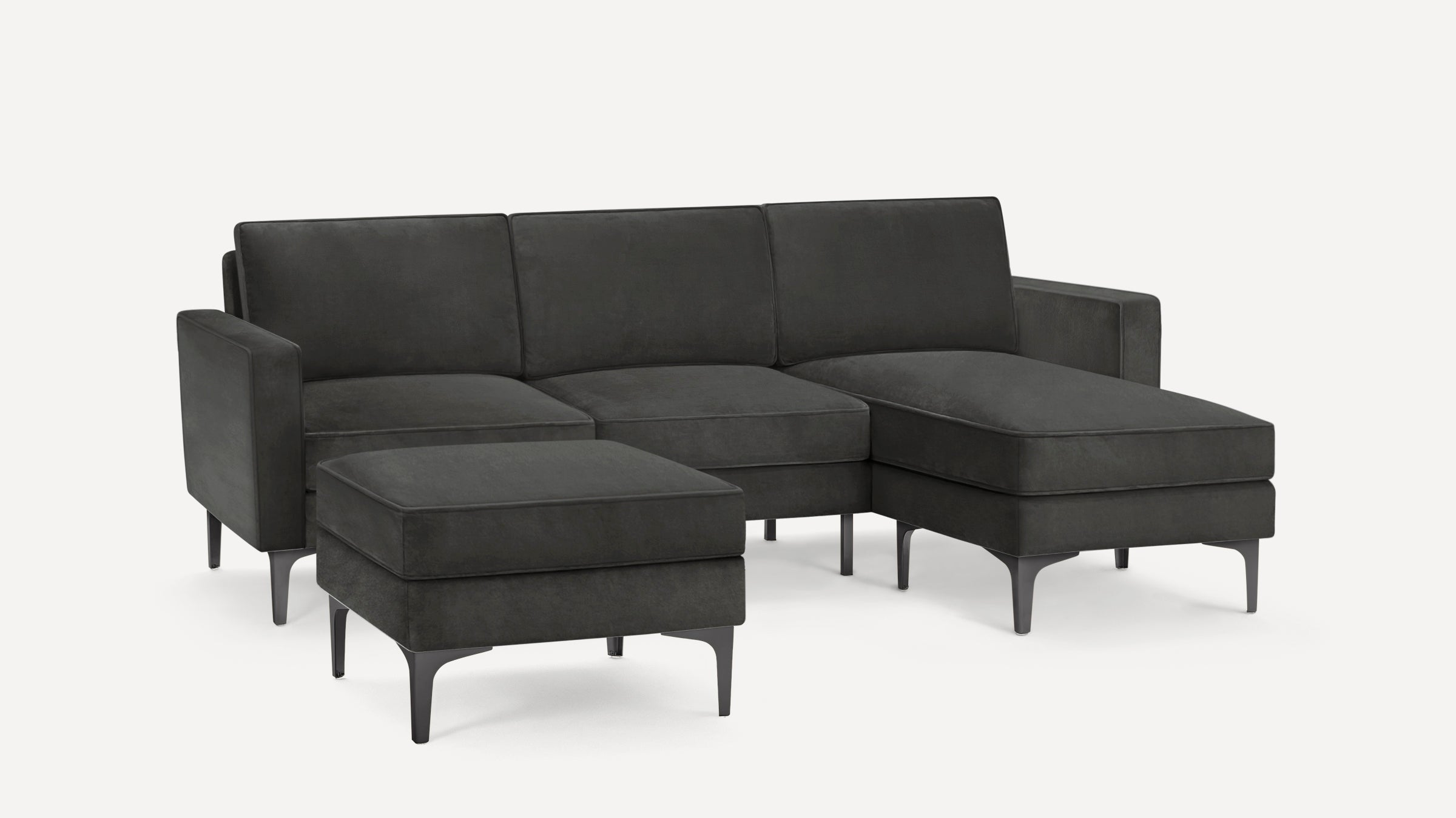 Dark gray sectional sofa with clean lines, metal legs, and a matching ottoman, designed for modern living spaces.