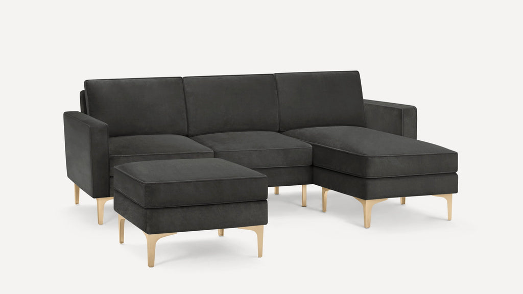 Dark gray modern sectional sofa with chaise lounge and matching ottoman, featuring sleek gold metal legs.