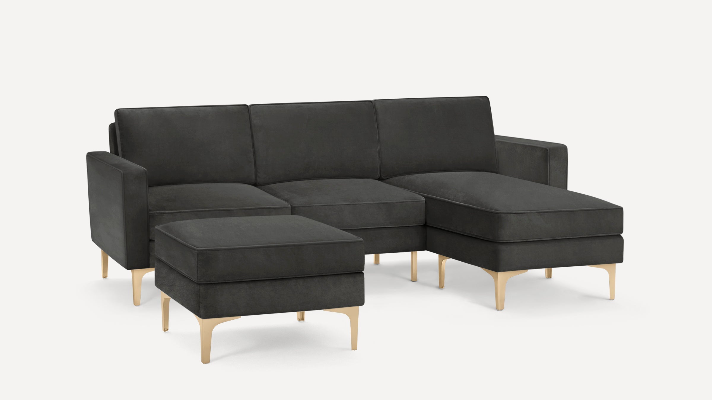 Dark gray modern sectional sofa with chaise lounge and matching ottoman, featuring sleek gold metal legs.