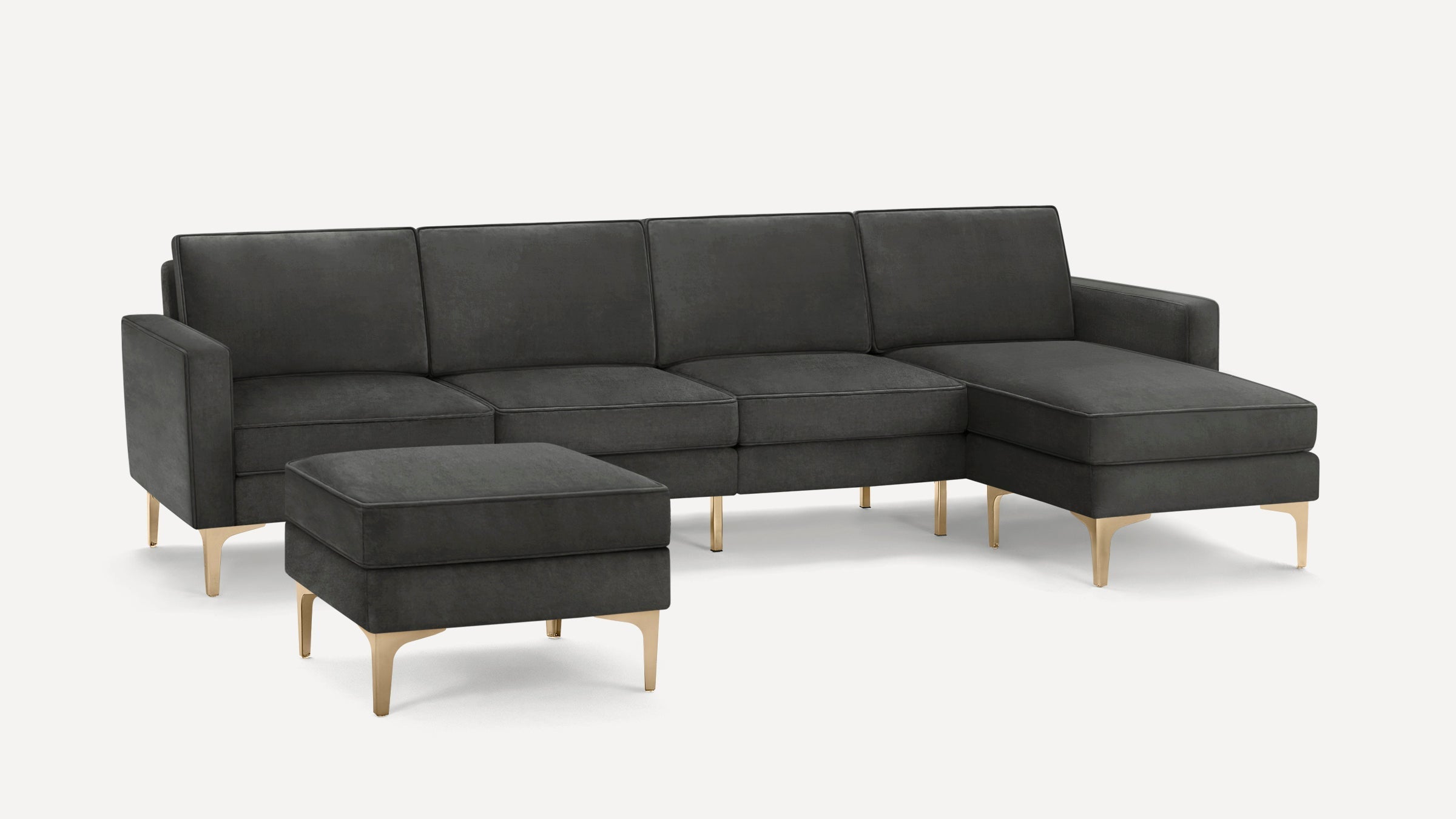 Dark gray contemporary sectional sofa with chaise and matching ottoman, supported by sleek gold metal legs.