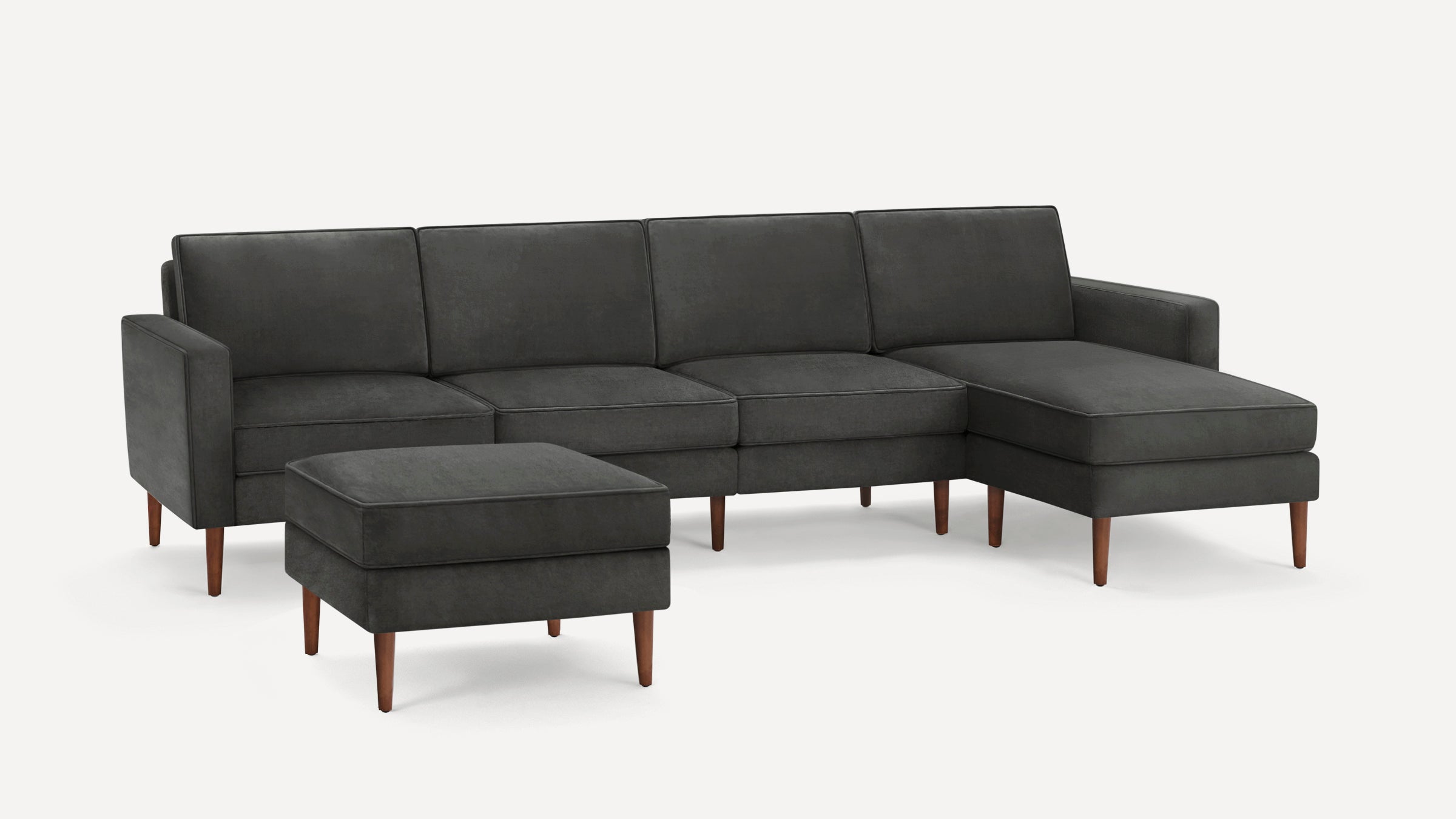Dark gray sectional sofa with a matching ottoman, featuring clean lines and wooden tapered legs.