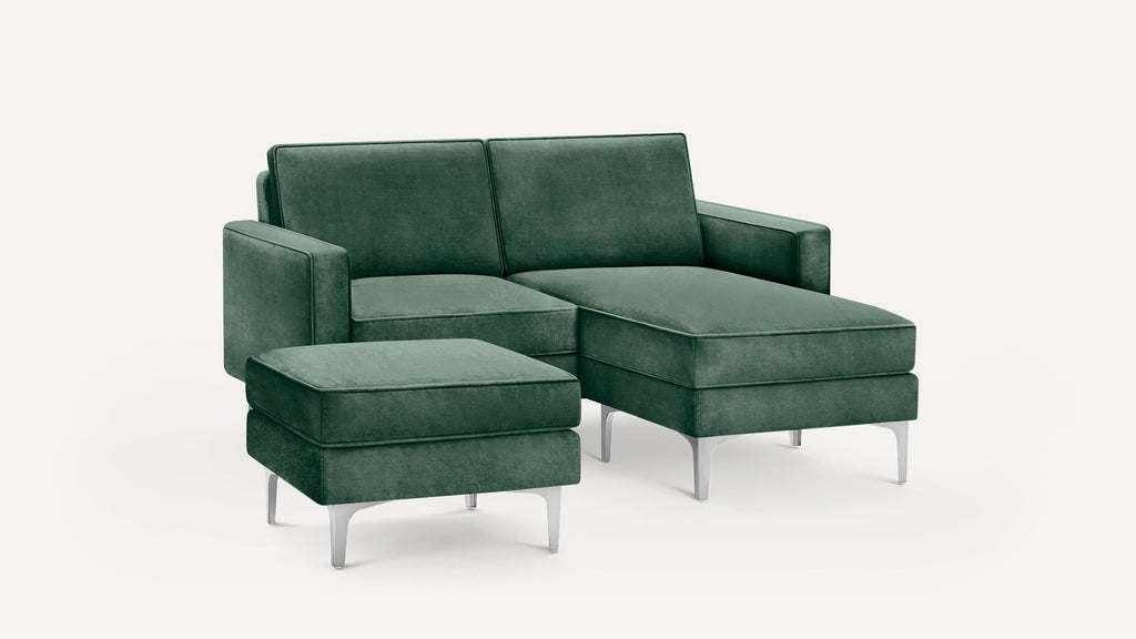 Modern green velvet sectional sofa with chaise lounge and matching ottoman, featuring sleek metal legs and clean lines.