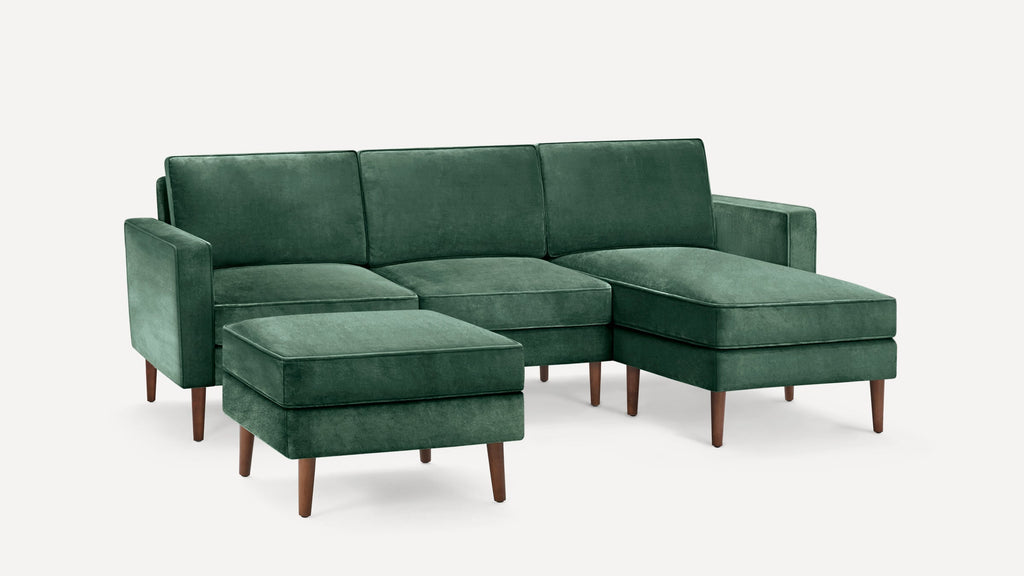 Green velvet sectional sofa with matching ottoman, wooden tapered legs, and clean, modern lines.