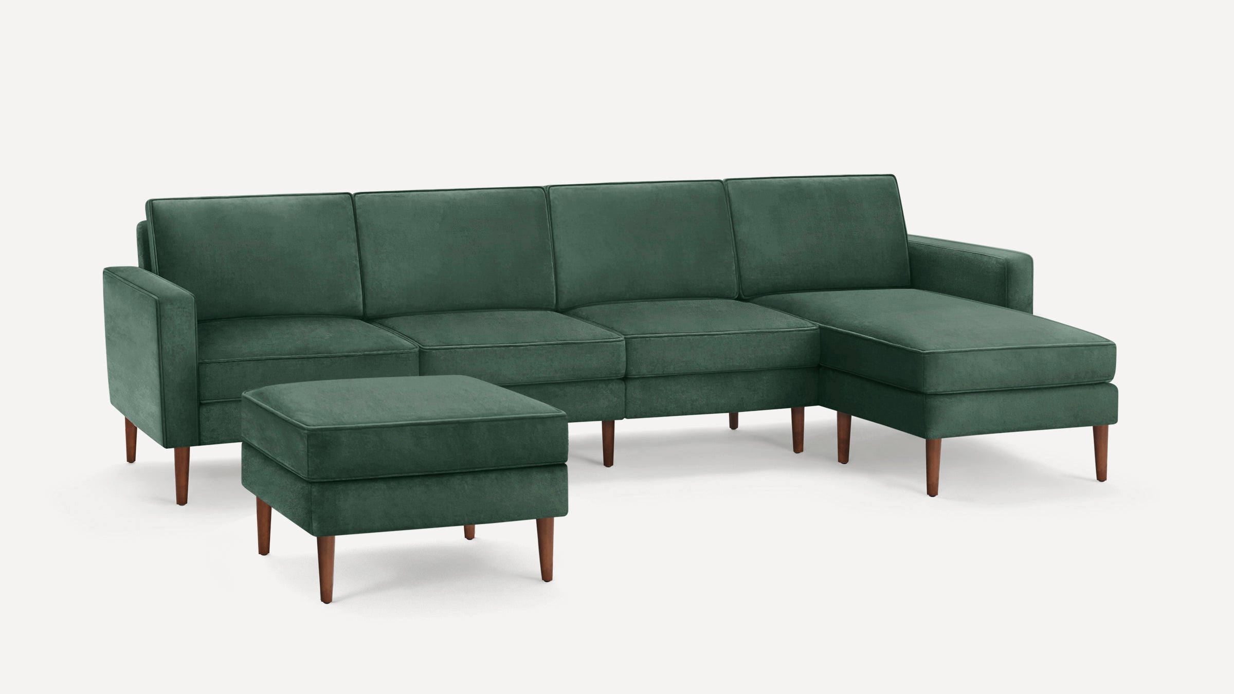 Modern dark green sectional sofa with chaise lounge and matching ottoman, featuring wooden tapered legs and clean lines.