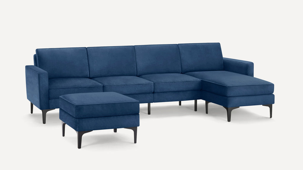 Modern sectional sofa in deep blue velvet fabric with clean lines, black legs, and matching ottoman, ideal for contemporary living rooms.