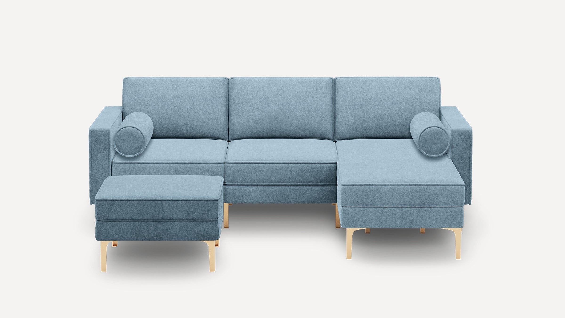 Modern light blue sectional sofa with chaise lounge and matching ottoman, featuring gold metal legs and cylindrical side pillows.