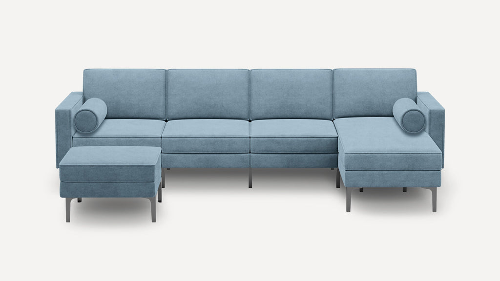 Light blue modern sectional sofa with a chaise lounge and matching ottoman, featuring metal legs and cylindrical pillows.