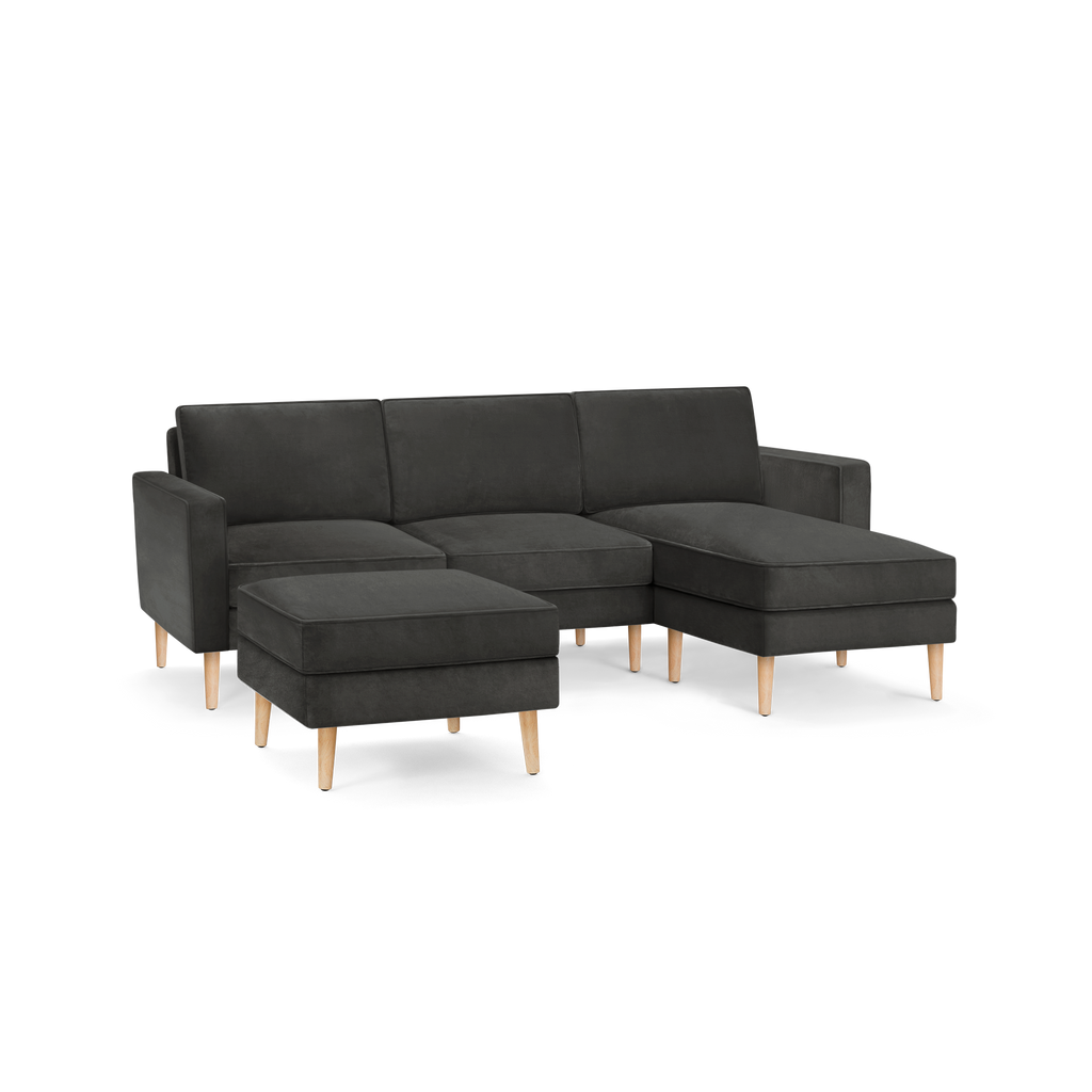 modern dark gray sectional sofa with wooden legs and matching ottoman, featuring a clean, minimal design