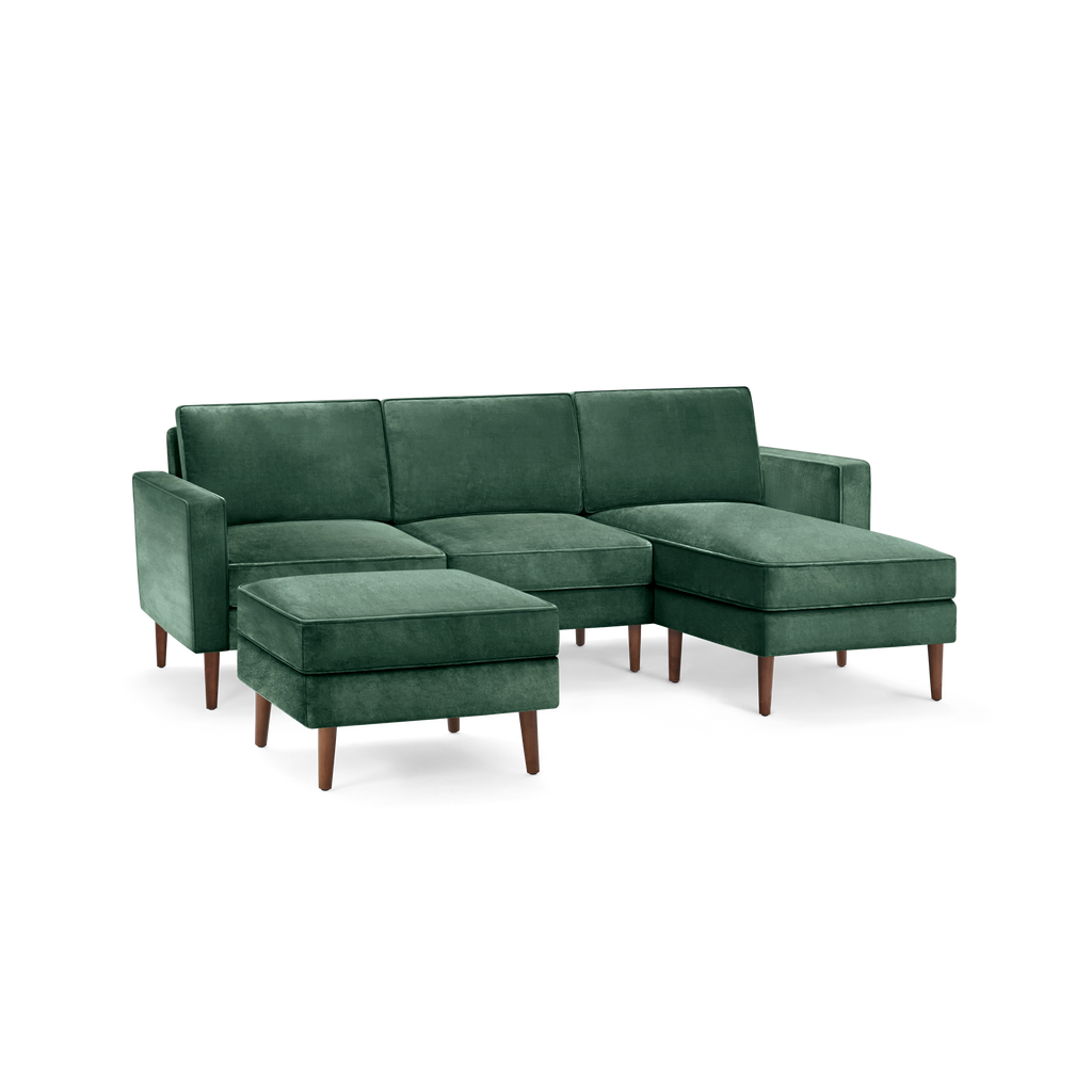 modern l - shaped sectional sofa with green velvet upholstery, wooden legs, and matching ottoman, designed for comfort and relaxation