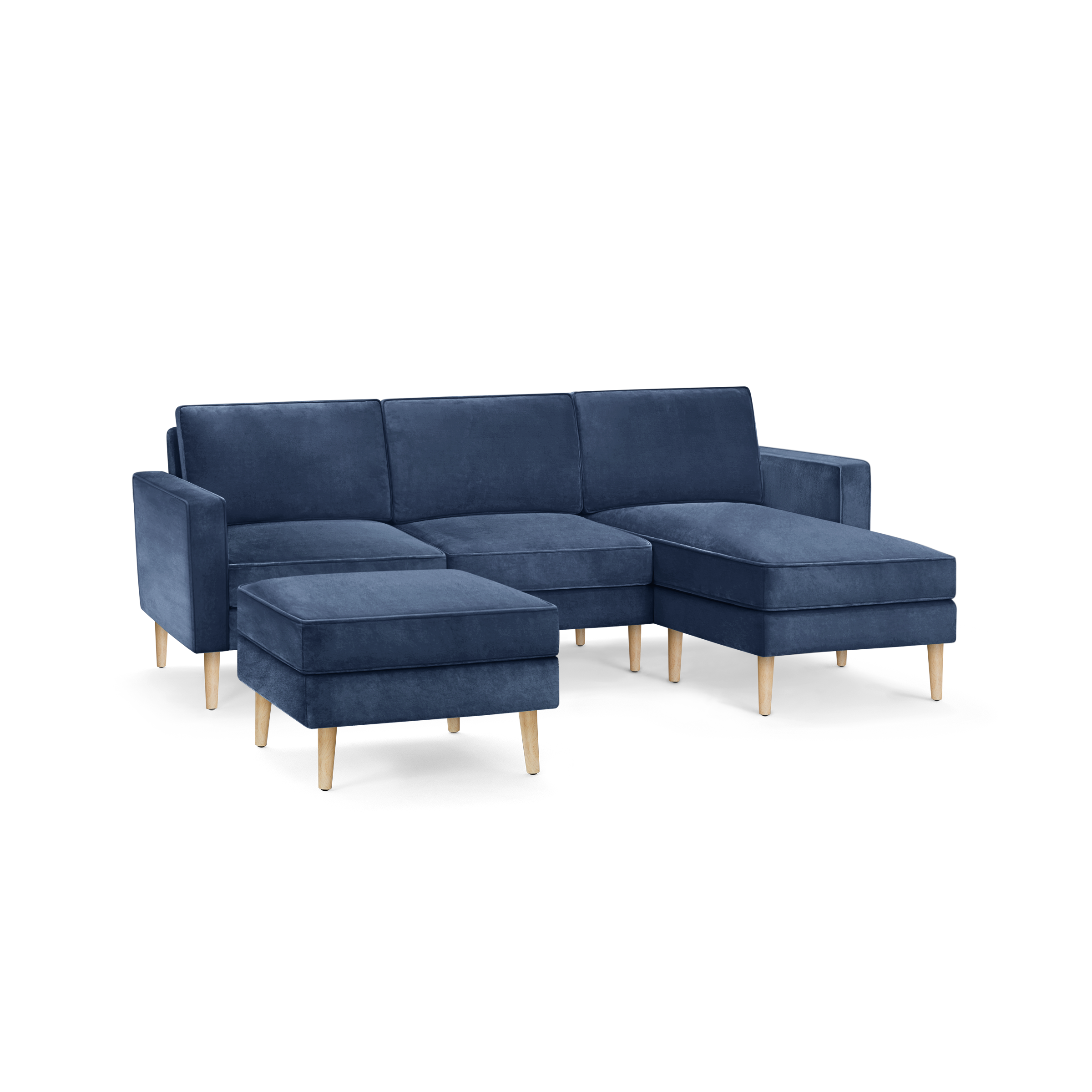 modern blue velvet sectional sofa with wooden legs and matching ottoman, featuring a clean, minimal design