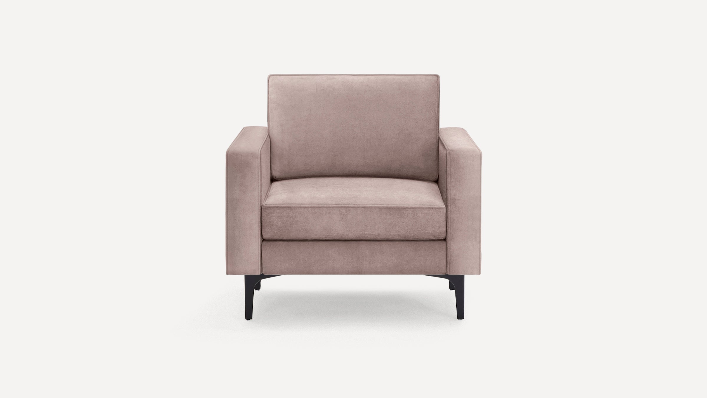 Front view of a modern dusty pink armchair with soft cushions and angled black metal legs on a plain white background.