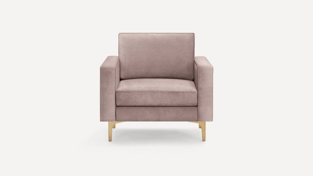 Modern single-seater armchair with soft mauve upholstery and gold metal legs, featuring wide armrests and cushioned backrest.