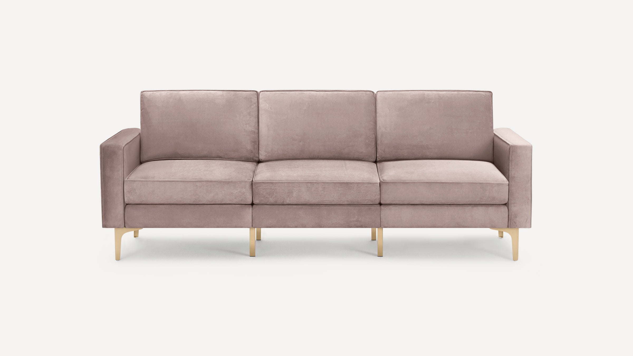 Modern three-seat sofa upholstered in soft dusty pink velvet with sleek gold metal legs and clean lines.