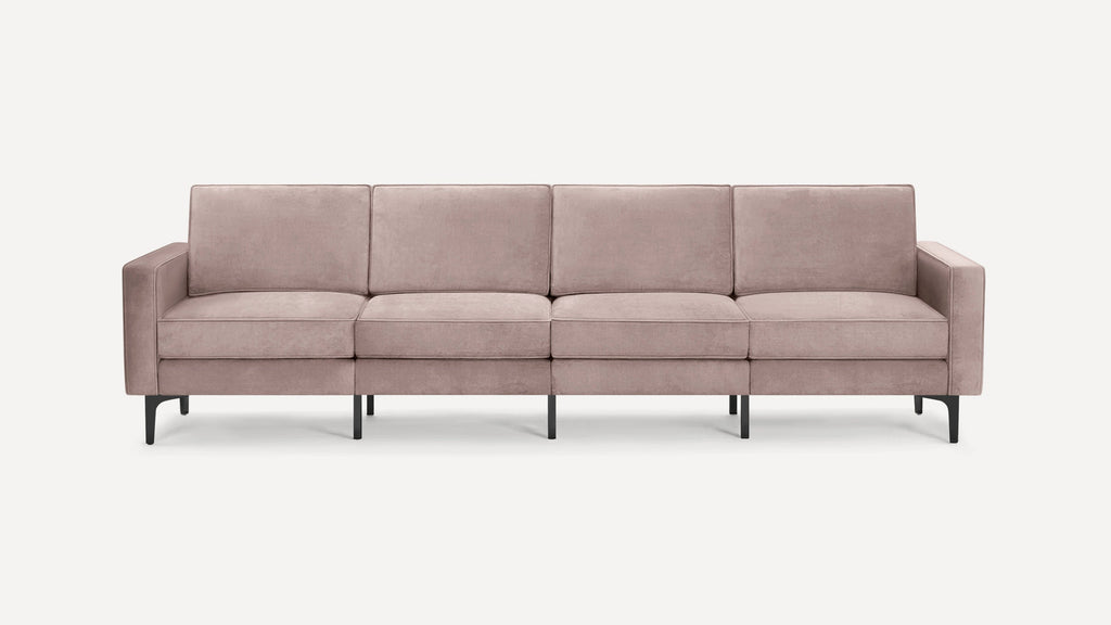 Modern four-seater sofa with soft mauve upholstery, square arms, and black slender metal legs on a white background.